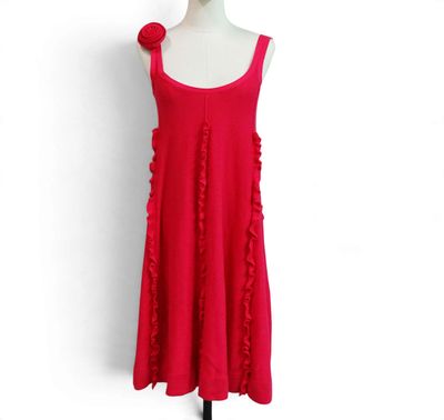 a red dress with ruffles on it on a mannequin stand