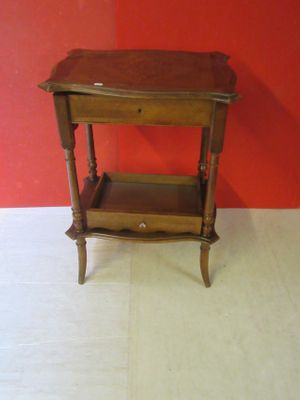 a small wooden table with a drawer on it