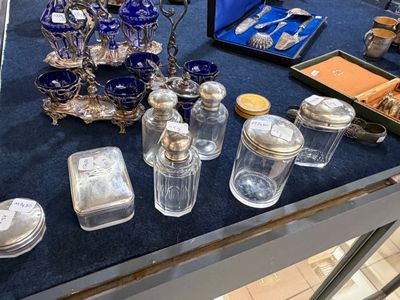 une table sur laquelle sont disposés de nombreux objets en argent et en verre