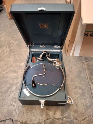 une valise posée par terre, contenant un tourne-disque