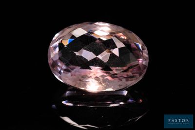 a close up of a pink diamond on a black surface