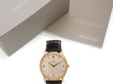 un gros plan sur une montre dans un coffret, avec un autre coffret en arrière-plan