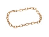 gros plan d'un bracelet en chaîne en or sur fond blanc