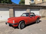 une voiture de sport rouge garée devant un garage