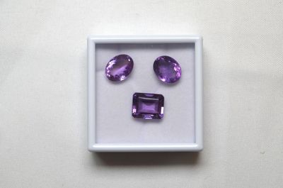 des améthystes violettes dans une boîte blanche posée sur une surface blanche