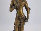 une statue en bronze représentant une femme tenant une fleur à la main