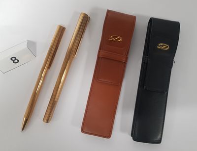 two pens and a pen case sitting on top of a table