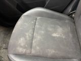 the dirty seat of a car with a dirty cloth on it
