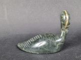 a close up of a statue of a duck on a black surface