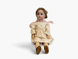 an image of a doll sitting on a white surface with a white background