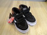 todd ' s black and white vans slip - ons on a wooden surface