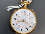 une montre de poche en or suspendue à un cordon