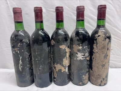 four bottles of wine are lined up in a row on a table