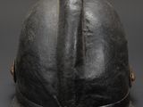 an old black helmet on a gray surface with a black background