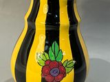 un vase jaune et noir orné de fleurs peintes