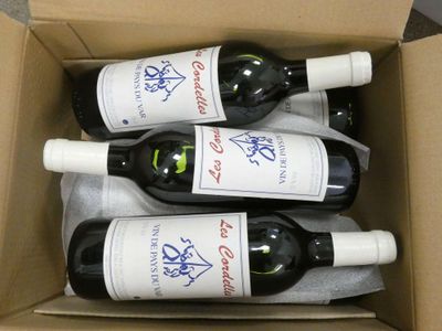 quatre bouteilles de vin dans une boîte en carton posée sur une table