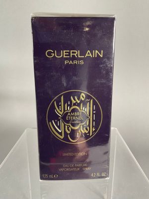 guerlain paris perfume in a clear box on a clear surface