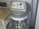 une photo d'un mixeur dans une cuisine, avec un micro-ondes en arrière-plan