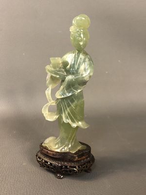 statue of a woman in a green dress holding a flower
