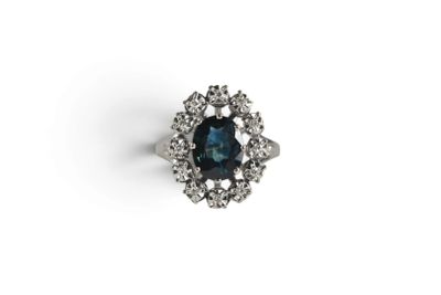 a close up of a ring with a blue stone surrounded by white diamonds