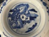 a blue and white bowl with a picture of a man riding a horse