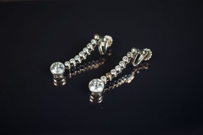 une paire de boucles d'oreilles ornées de diamants sur un fond noir