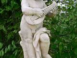 a statue of a boy playing a guitar on a pedestal