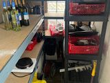 a room with a shelf with bottles of wine and other items