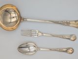 three silver spoons and a fork on a table