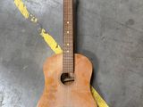 une personne se tient à côté d'une guitare posée par terre