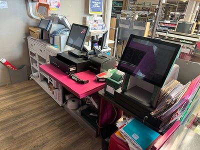a desk with two computers and a printer on it