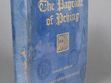 a blue book with gold writing on it sitting on a gray surface