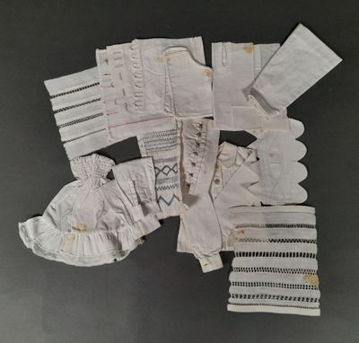 several pairs of white gloves and mitts are laid out on a table