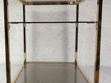 a brass and glass display case on a white surface