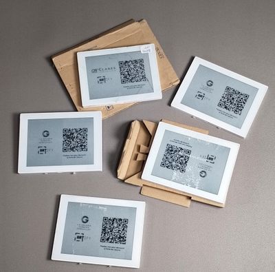 plusieurs feuilles de papier sur lesquelles figure un code QR, posées sur une table
