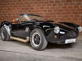 an image of a black sports car parked in front of a brick wall