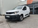 une camionnette blanche garée devant un bâtiment dans un parking