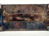 a metal box with a metal handle on a white surface