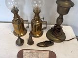trois lampes anciennes en laiton et un papier posés sur une table