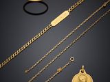 a collection of gold jewellery including a coin, a ring and a bracelet