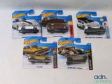 cinq petites voitures Hot Wheels exposées sur la table