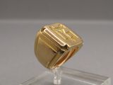 a gold ring that is sitting on top of a clear stand