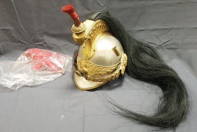 un casque sur lequel repose une longue mèche de cheveux noirs, posé sur une table
