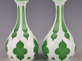 une paire de vases verts et blancs posés sur une table