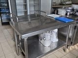 une grande table en acier inoxydable au milieu d'une cuisine