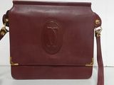 brown leather purse with gold accents on a white surface