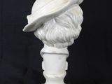 white marble bust of a man with a hat on a black background