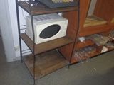 un micro-ondes et un ordinateur portable posés sur une étagère dans une pièce