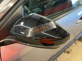 reflection of a car with a sticker on it ' s side mirror