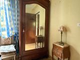 a mirror in the corner of a room next to a dresser